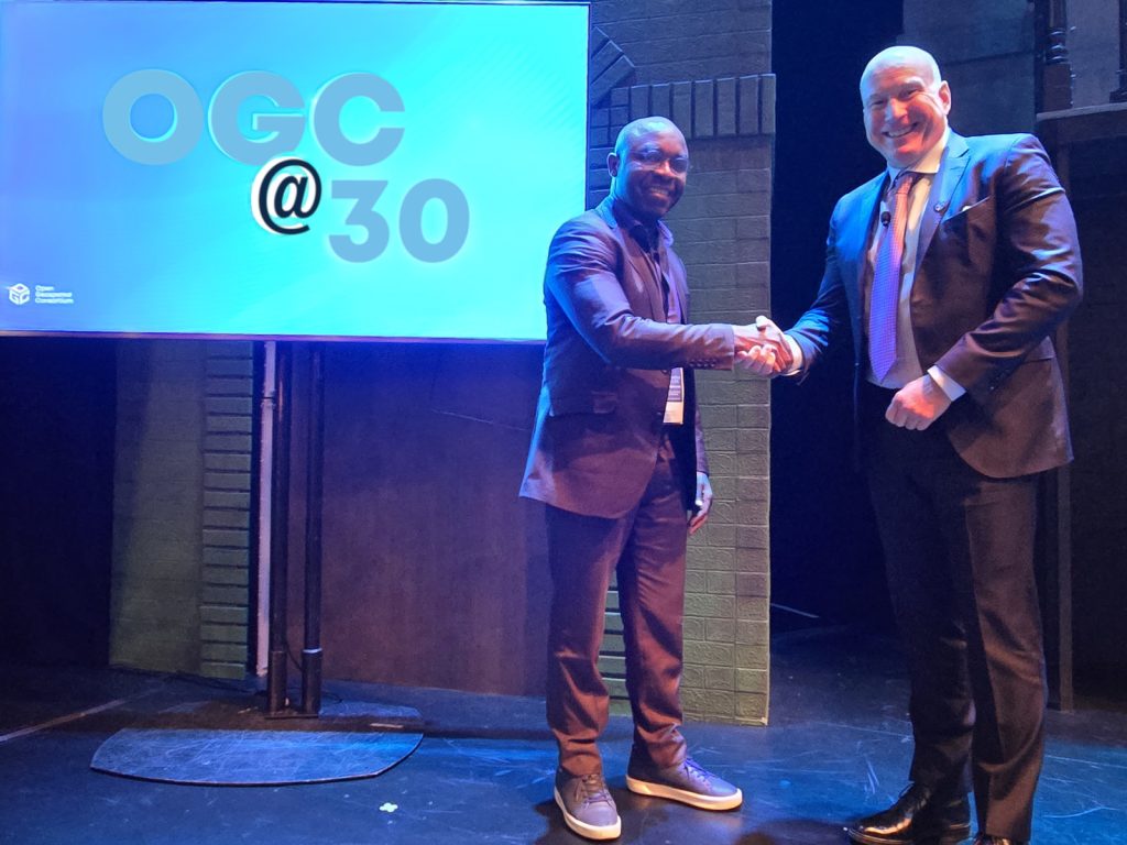 AfroLeadership President Charlie Martial Ngounou shakes hands with OGC CEO Peter Rabley during the OGC@30 Anniversary event.